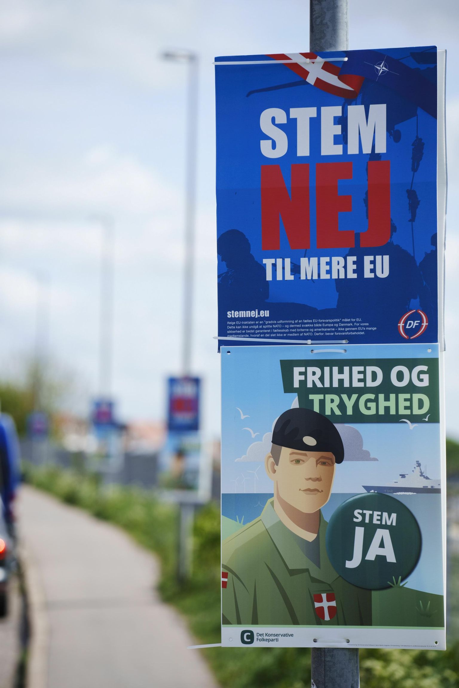Konservatiivse Rahvapartei plakat Randersi tänaval kutsub inimesi toetama Taani osalemist ELi kaitsepoliitikas. Taani Rahvapartei reklaam selle kõrval ärgitab andma homsel referendumil vastuhäält. 