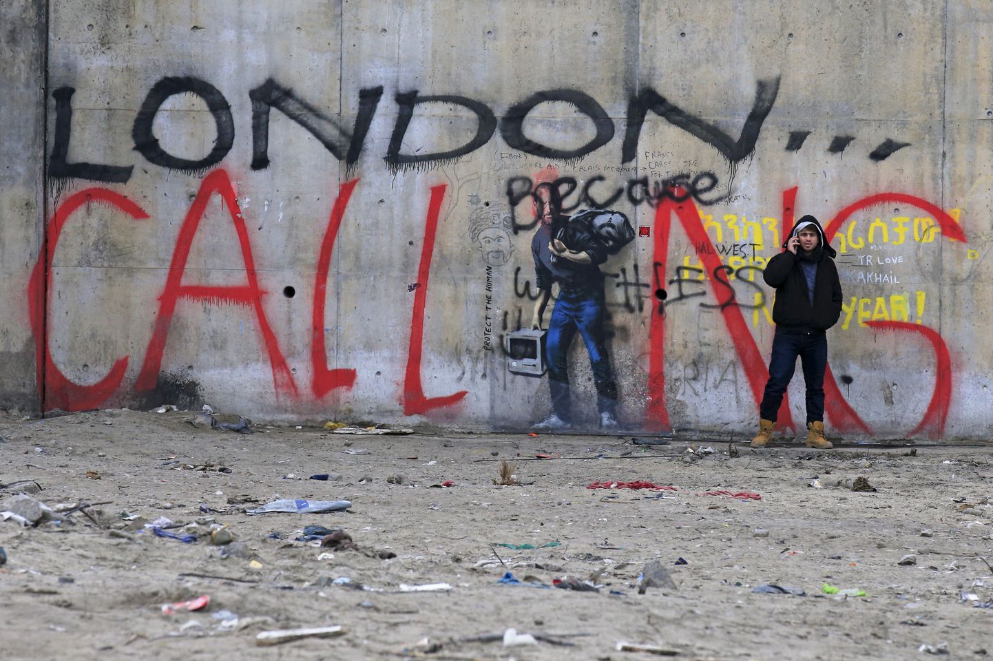 Calais sisserändajad graffiti juures, mis ütleb «London kutsub»