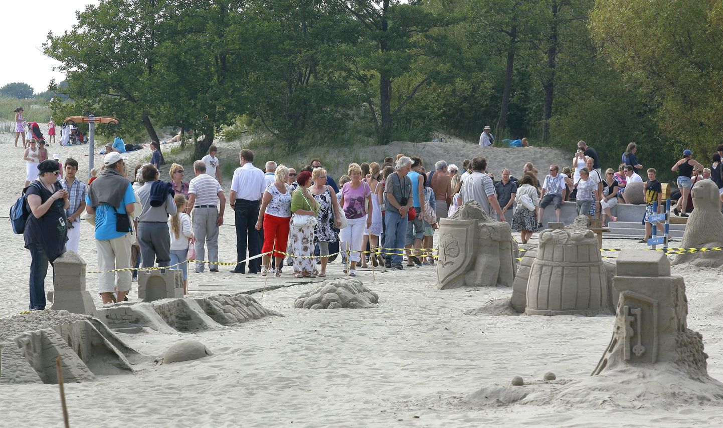 Paljud inimesed uudistavad rannas liivaskulptuure.