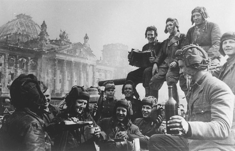 Nõukogude punaarmeelased 1945 Berliinis, taga on näha lahingus kannatada saanud Riigikantselei hoonet