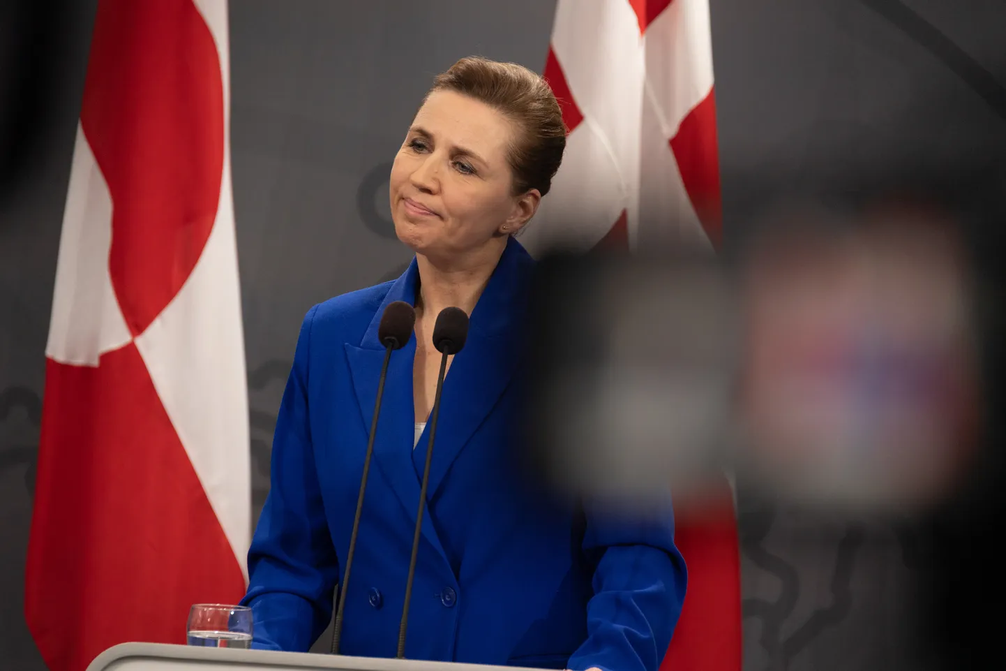 Taani peaminister Mette Frederiksen Kopenhaagenis pressikonverentsil Gröönimaa ja Taani lipu taustal.