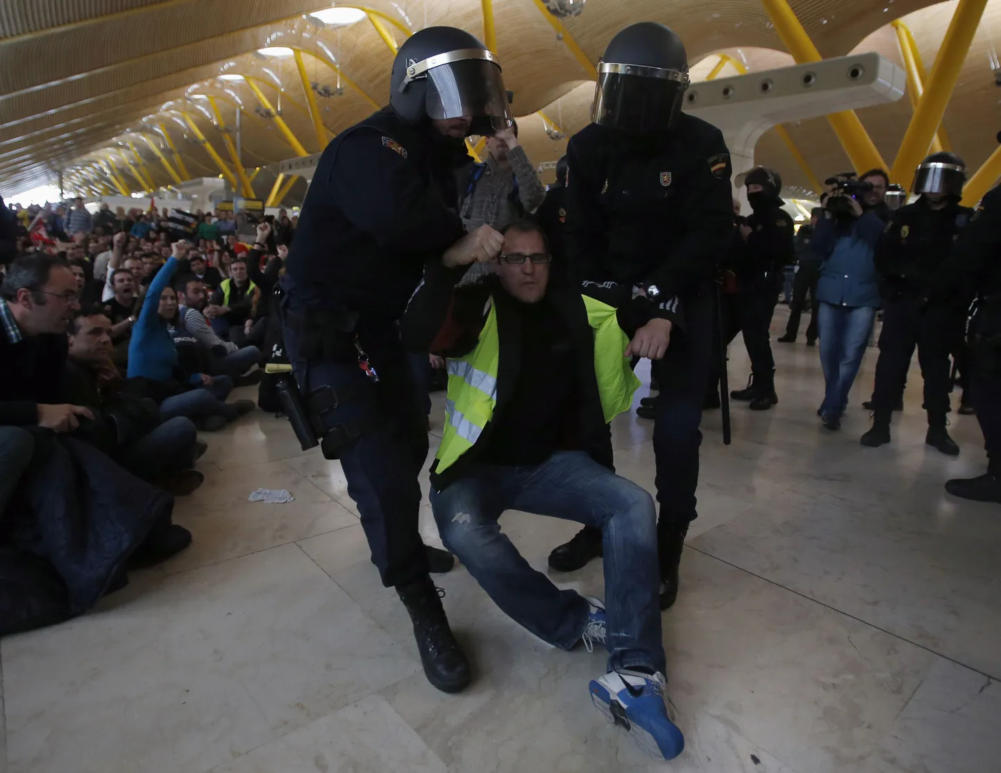 Hispaania politseinikud lohistavad terminalist minema ühte Iberia töötajat.