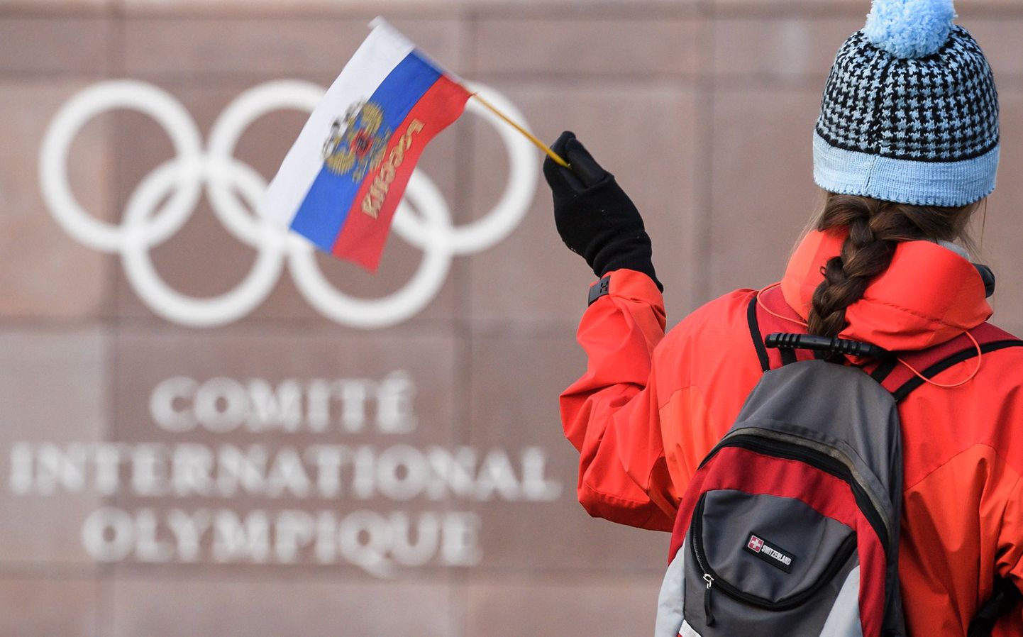 Российский флаг на фоне логотипа Международного олимпийского комитета.