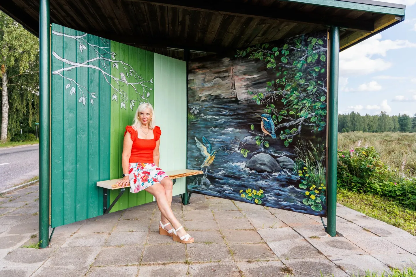 Kunstnik Epp Metsaluige kõrval olevalt maalilt paistab Taevaskoja Nõiakivi.