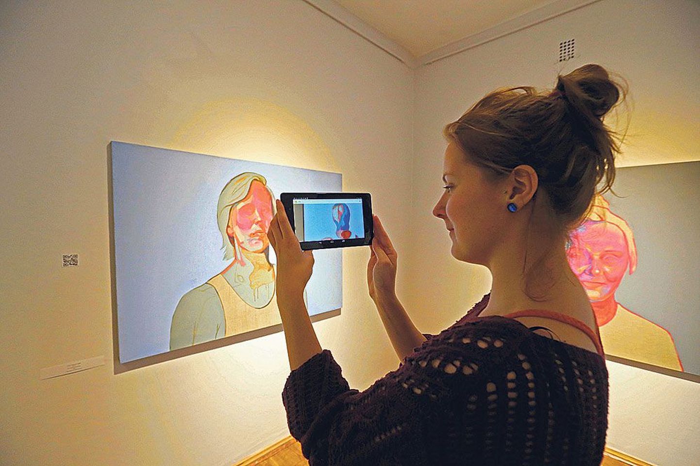 Olivia Parmasto näitab, kuidas tema lõputööd «ID» koos tahvelarvutiga vaadata.