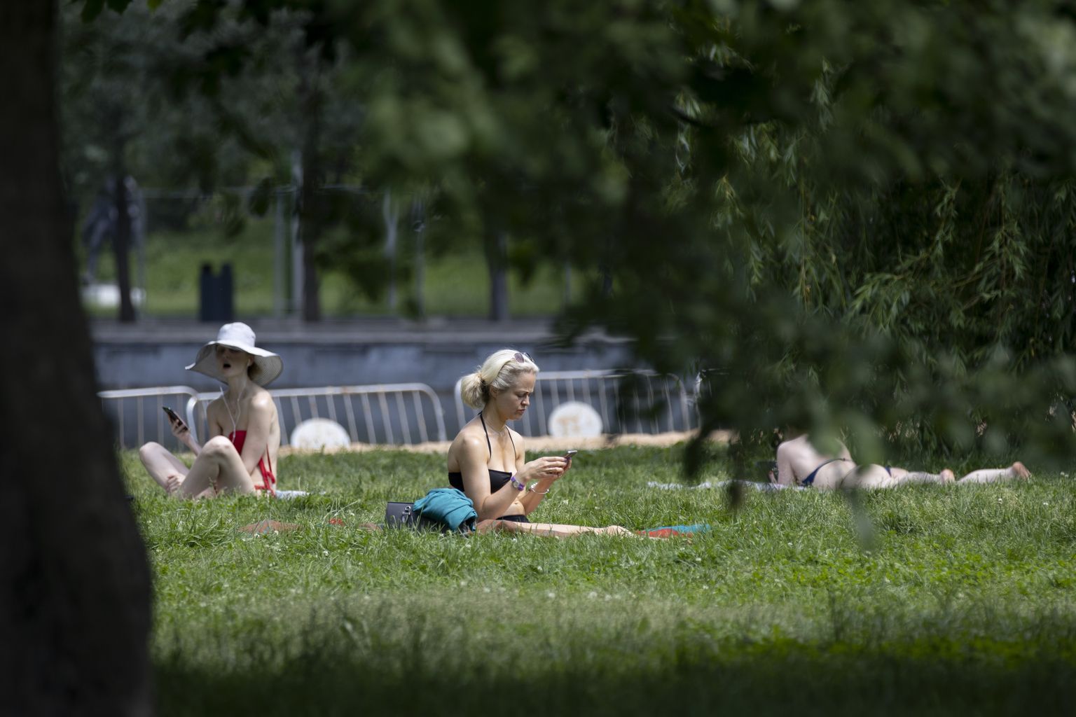 Cilvēki karstā vasarā atpūšas parkā. Ilustratīvs foto