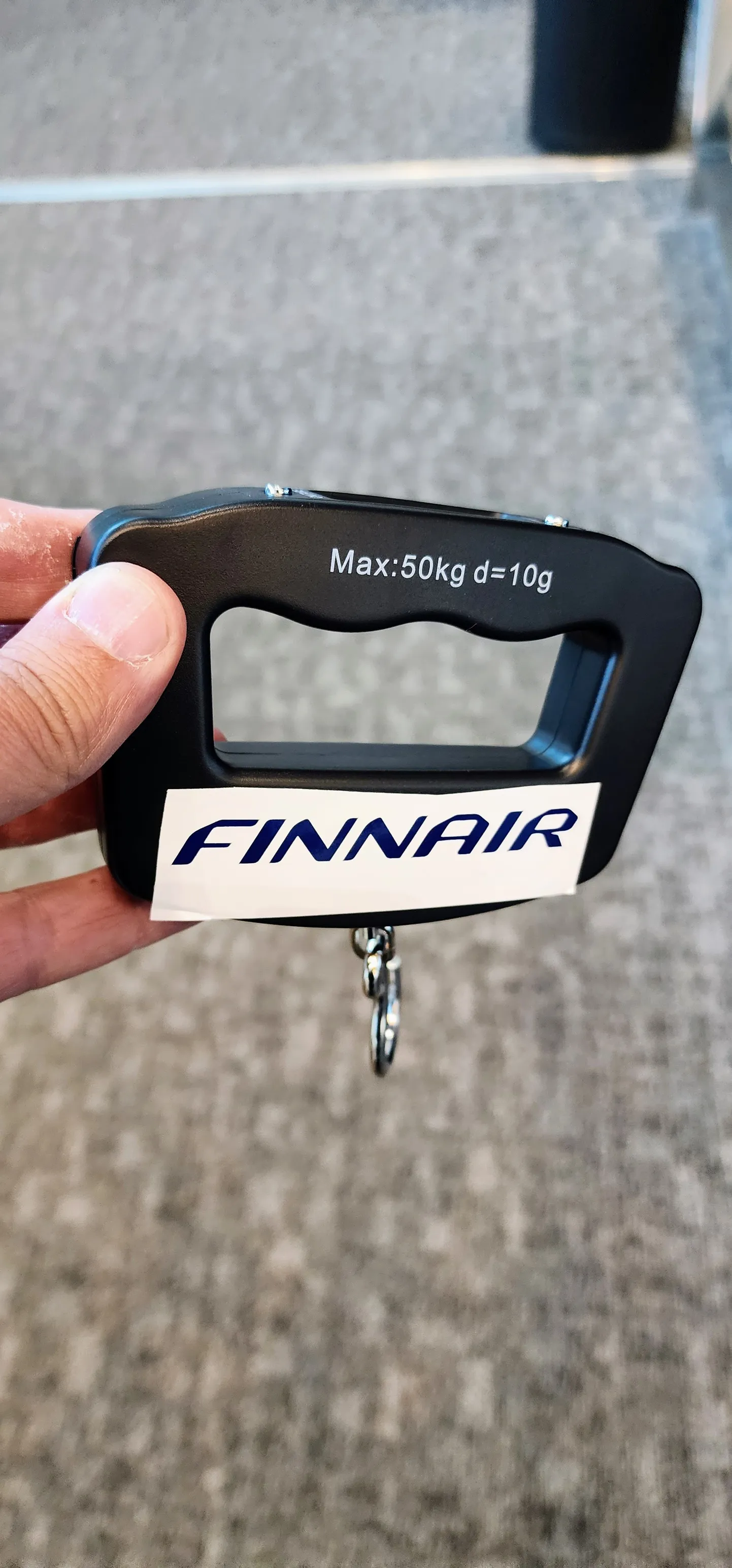 Ручные весы, используемые сотрудниками Finnair для взвешивания багажа в аэропорту Хельсинки.