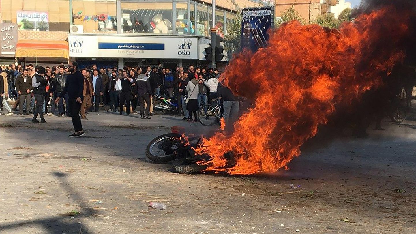 Põleva mootorratta ümber kogunenud Iraani meeleavaldajad 16. novembril Isfahanis.
