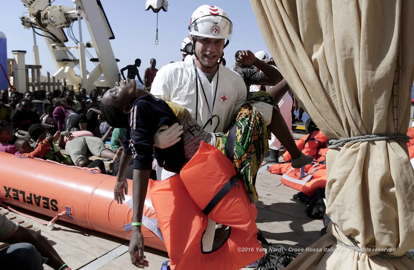 Itaalia Punase Risti töötaja kannab kätel Liibüa ja Malta vahelistest vetest päästetud migranti.