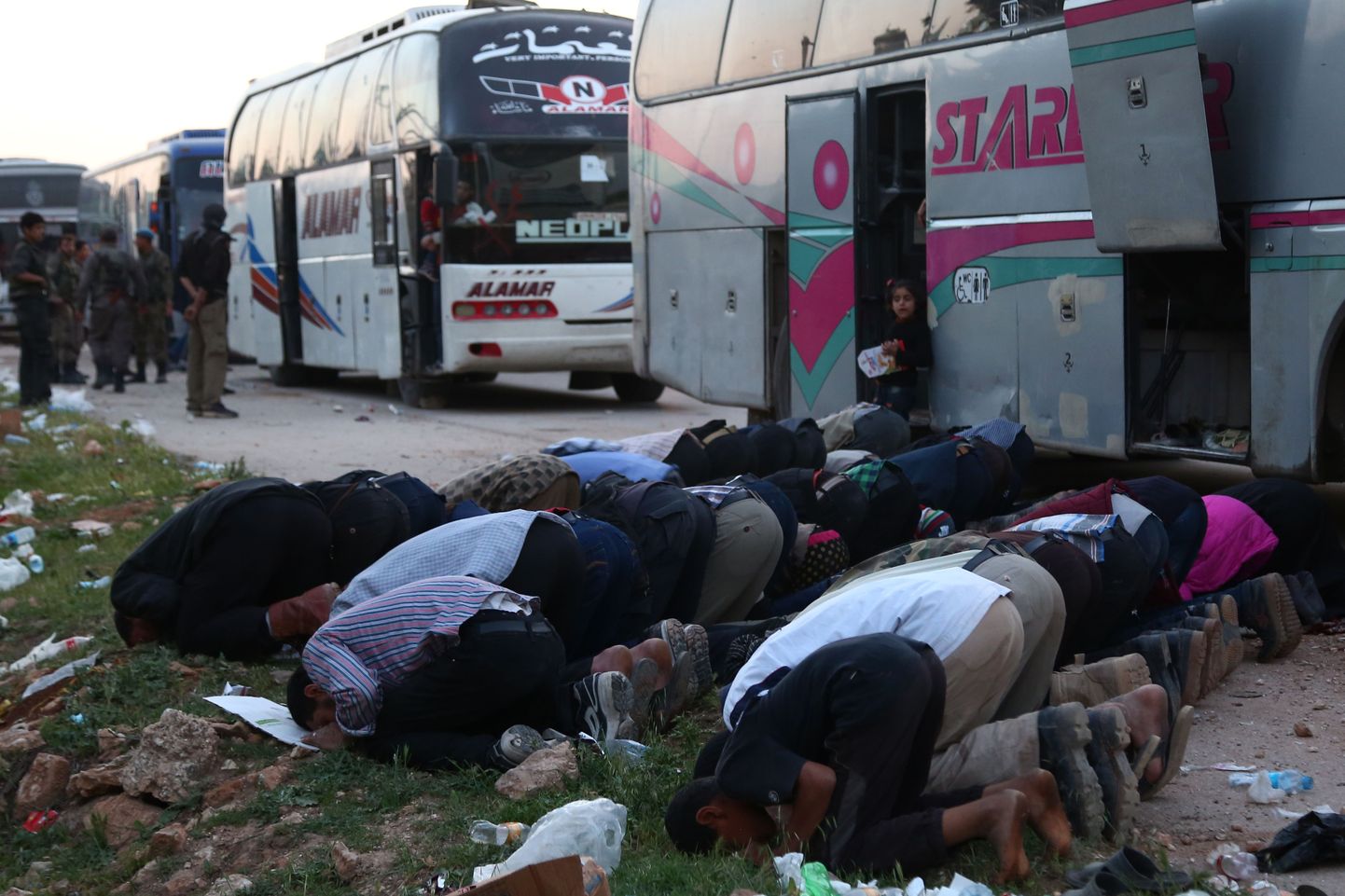 Ida-Ghoutast lahkujad palvetavad enne bussidele minekut.