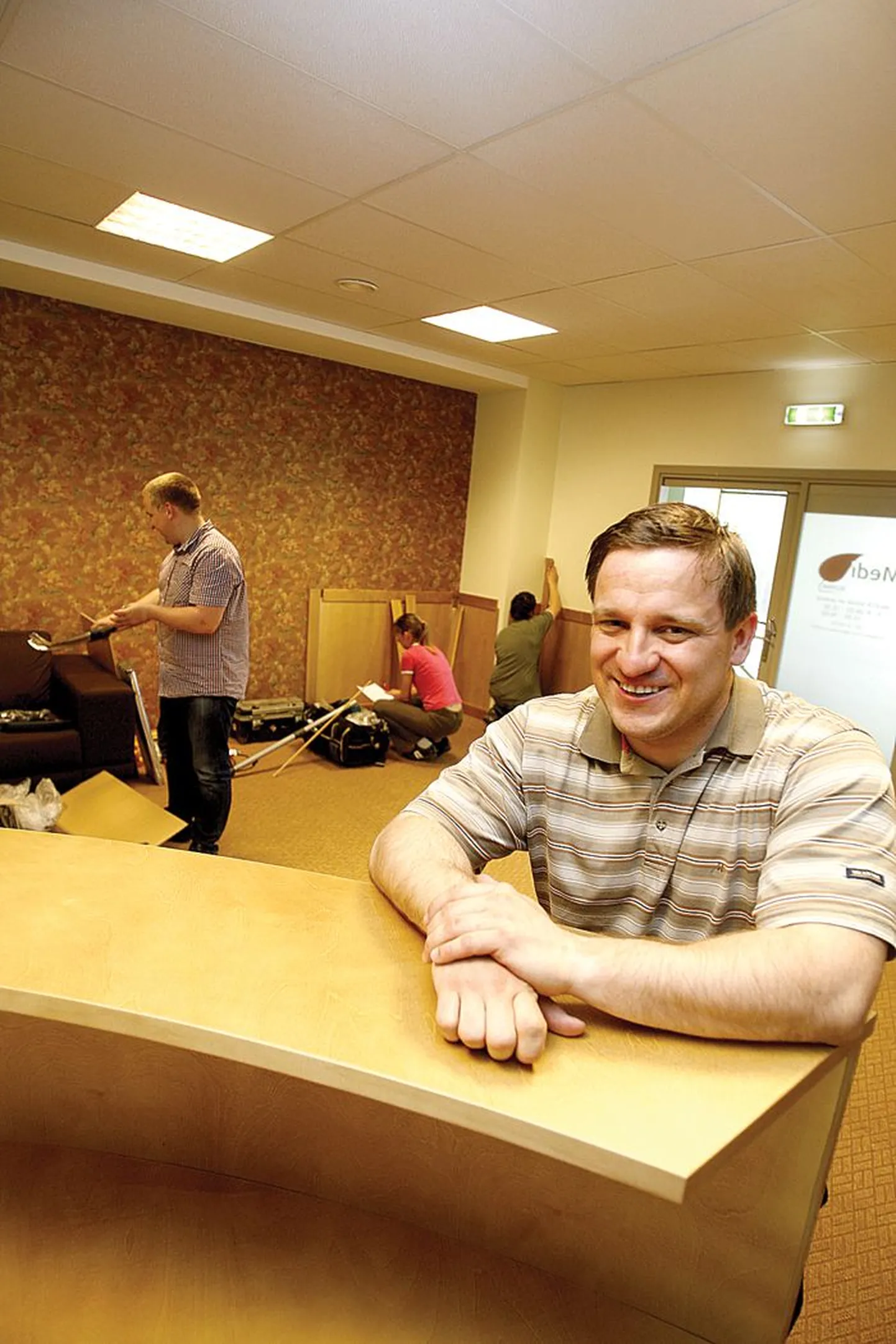 Meestearst Kristo Ausmees nõjatub uue tervisekliiniku vastuvõtulaua nurgale, tagaplaanil abilised, kes olid eile ennelõunal uute ruumide sisseseadmisega hoolega ametis.