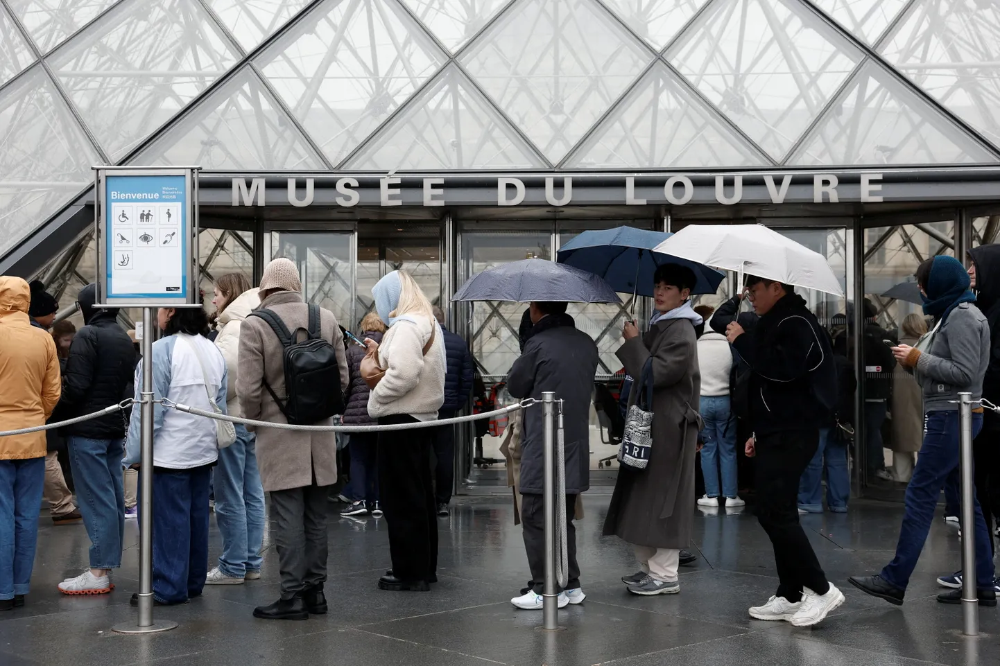 Turistid soovivad Louvre'i pääseda vihmasel päeval.