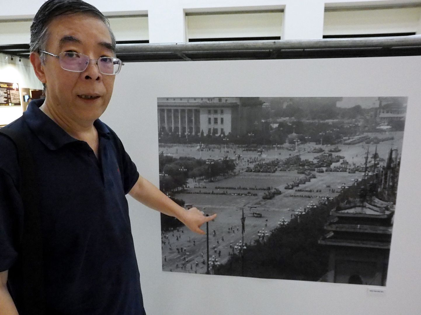 Hiina dissident Wu Yenhua Taiwani pealinnas Taipeis Tiananmeni veresaunale pühendatud näitusel viitamas fotole demokraatiameelsete meeleavalduste mahasurumisel osalenud tankidest.