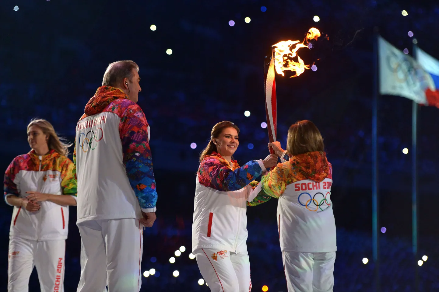 Алина Кабаева передает эстафету олимпийского огня Ирине Родниной.