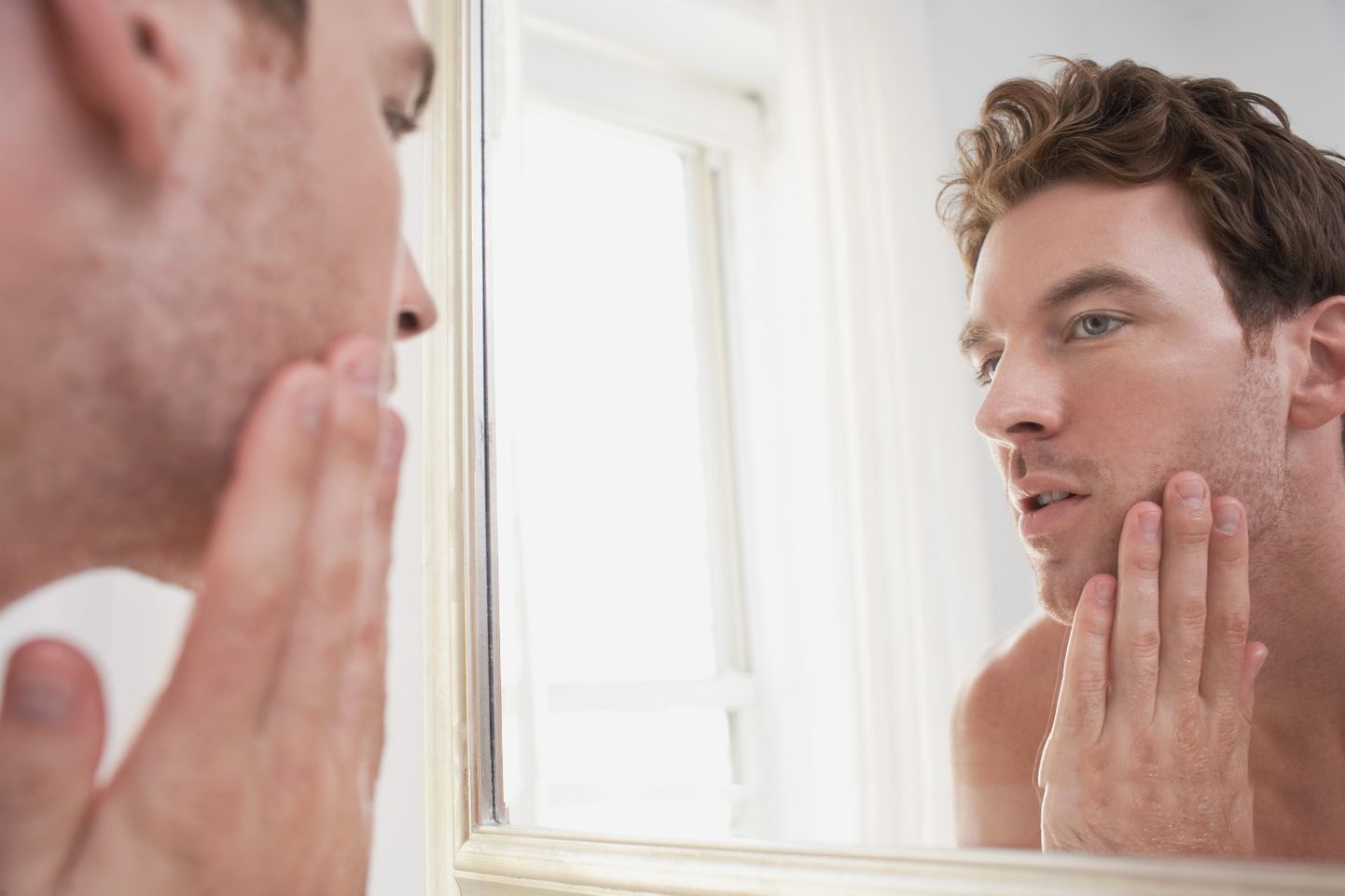Man Examining His Stubble In Mirror