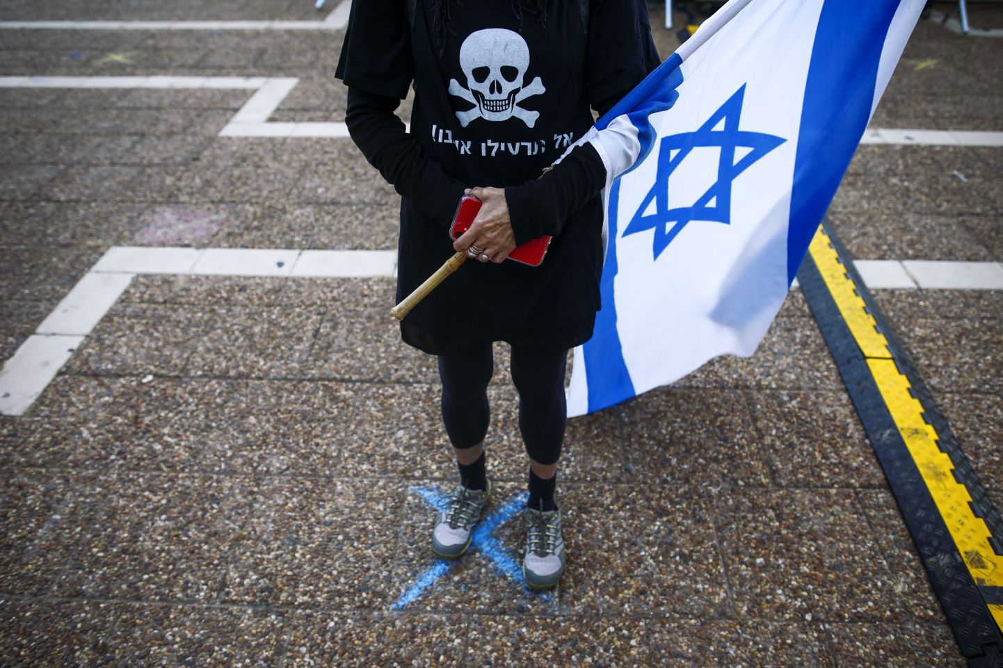Asfaldile kriidiga joonistatud rist on aidanud viimaste nädalate meeleavaldustel hoida Iisraelis inimeste vahel vajalikku distantsi ning nii pole ka Tel Avivi politseil olnud põhjust sekkuda protestidesse korruptsioonis süüdistatava peaministri Benjamin Netanyahu vastu.