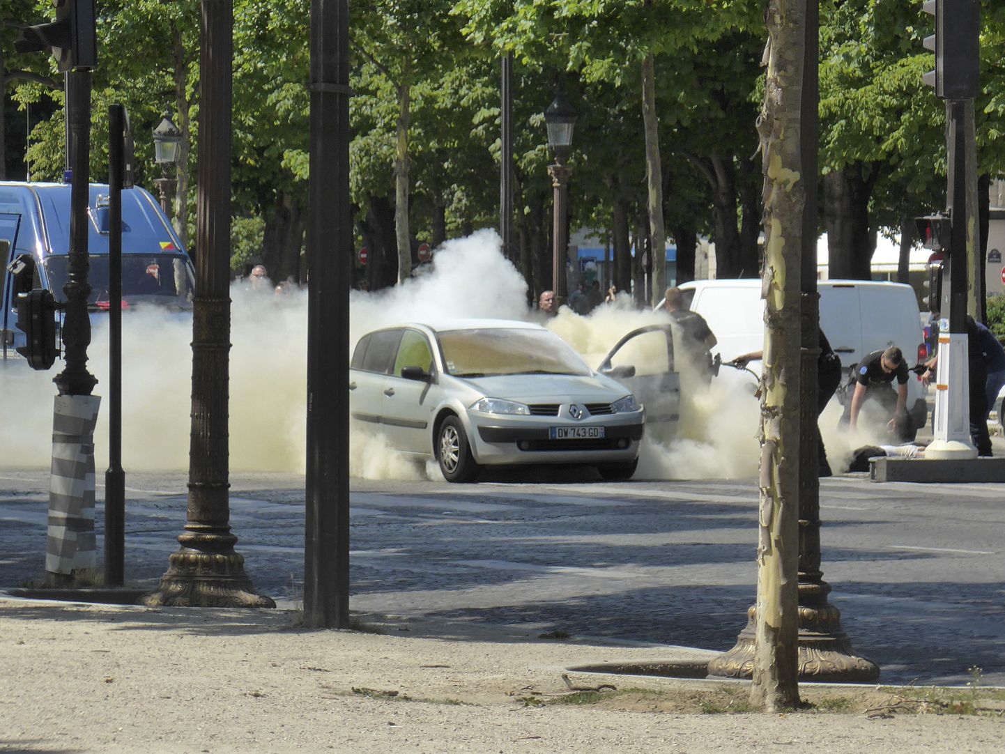 Politsei kustutab Pariisi kesklinnas politseikonvoid rünnanud ja põlema süttinud autot.