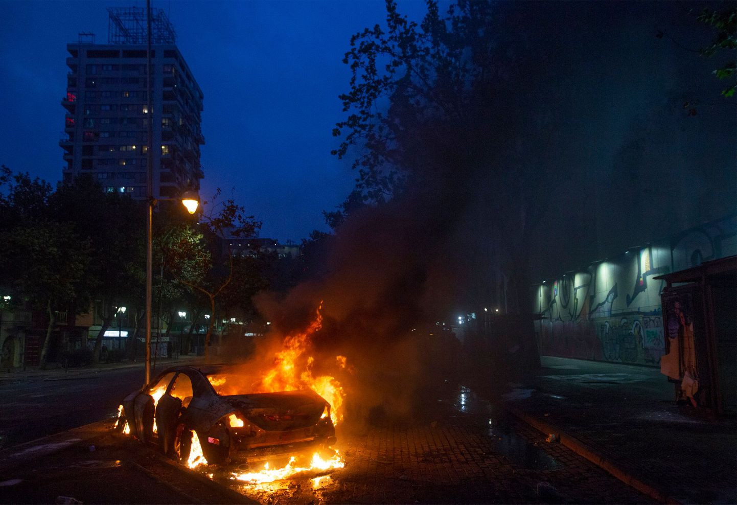 Tšiili pealinnas Santiagos rahutuste käigus põlema süüdatud auto.