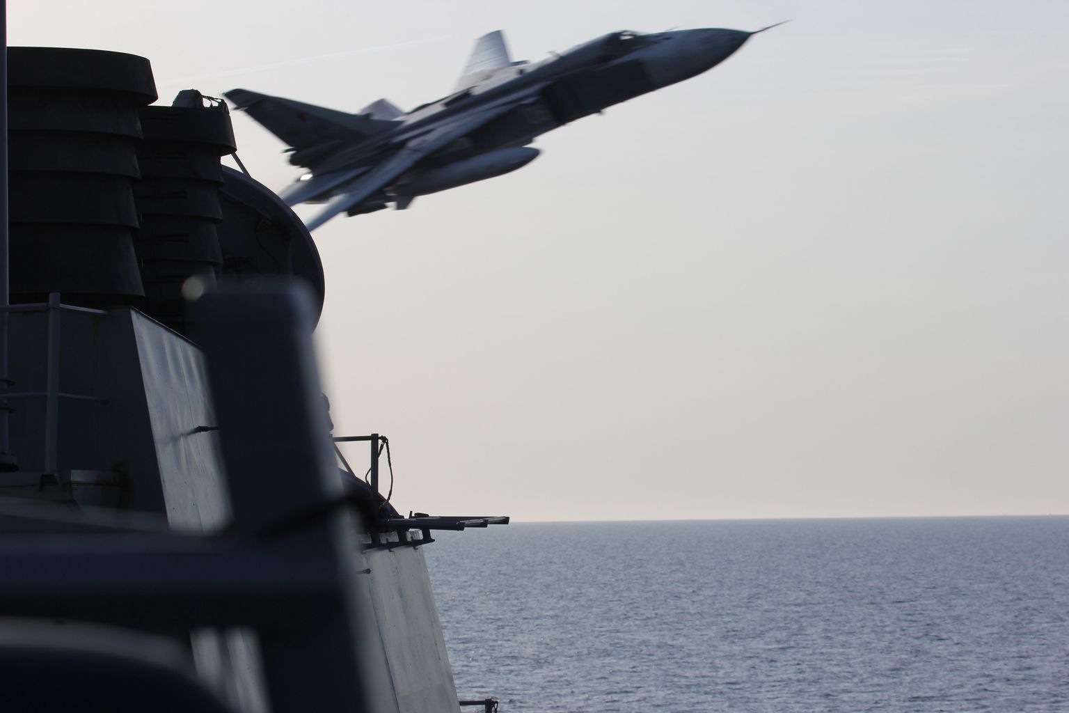 In this image released by the U.S. Navy, a Russian SU-24 jet makes a close-range and low altitude pass near the USS Donald Cook on Tuesday, April 12, 2016, in the Baltic Sea. The Russian attack planes buzzed the U.S. Navy destroyer multiple times on Monday and Tuesday, at one point coming so close, an estimated 30 feet, that they created wakes in the water around the ship, a U.S. official said Wednesday, April 13. (U.S. Navy via AP)