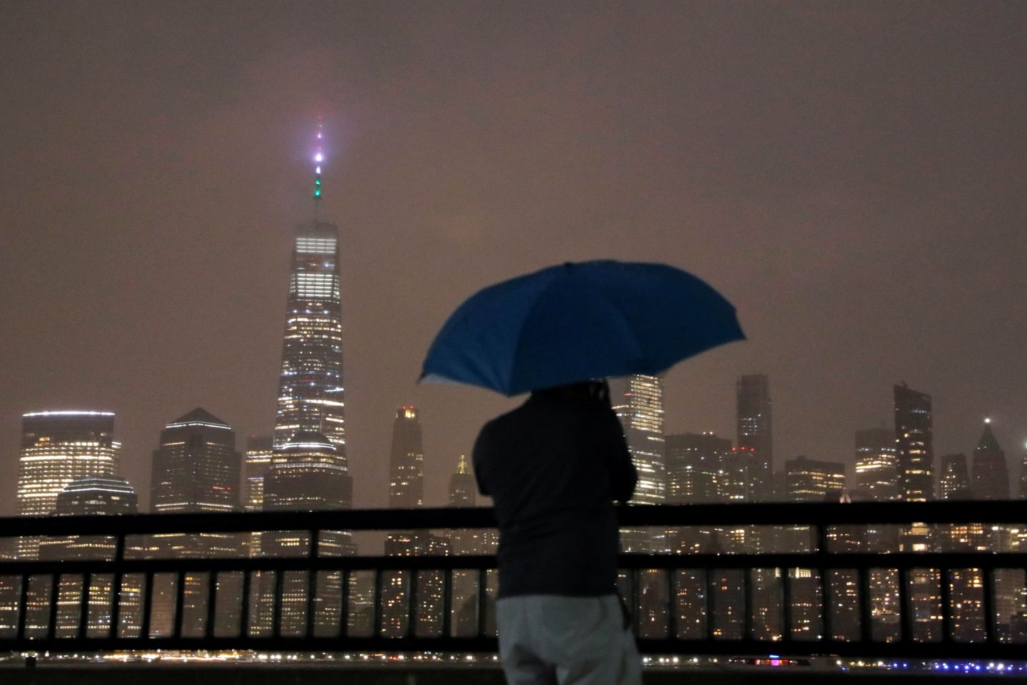 Inimene vihmavarjuga vaatab New Yorgi pilvelõhkujate poole ajal, mil piirkonnale on lähenemas orkaan Henri.