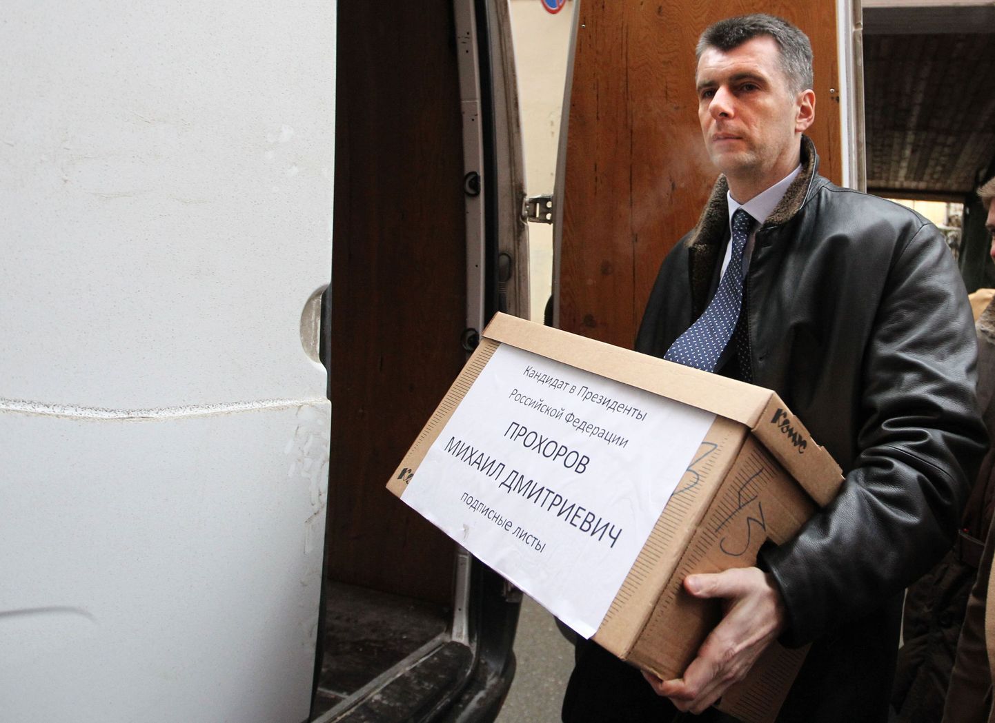 Mihhail Prohhorov kastiga, kus on toetusallkirju sisaldavad paberid.