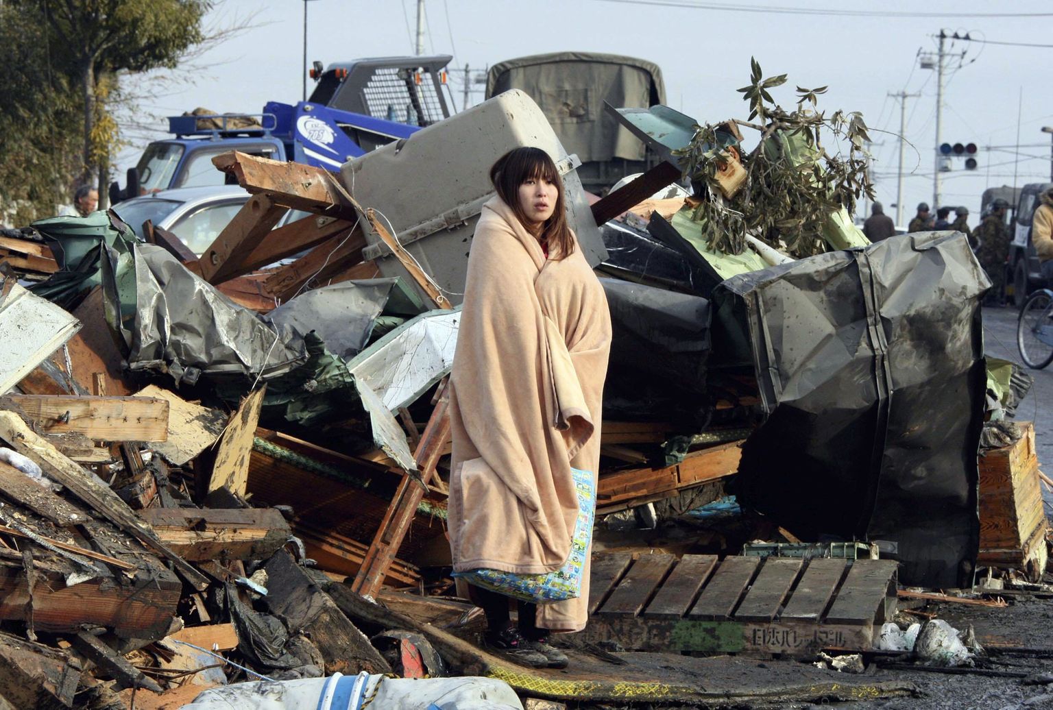 Jaapani looduskatastroofi järgset ülesehitust takistavad «kummitused». Fotol tekki mässitud ellujäänu Ishinomakis pärast tsunamit