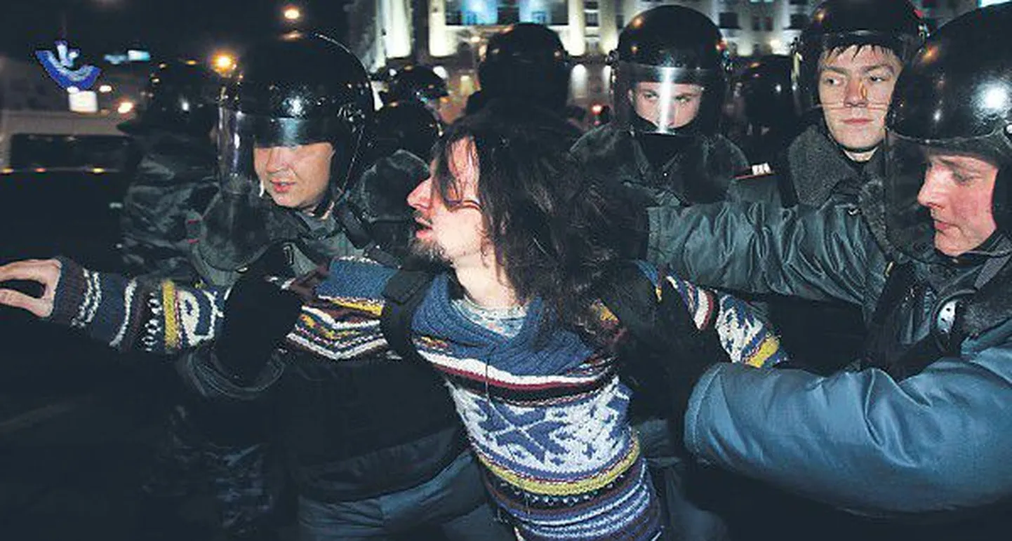 Полиция задерживает активиста во время митинга 6 декабря в Москве, прошедшего в знак протеста против результатов выборов в Госдуму и политики, проводимой властями России.
