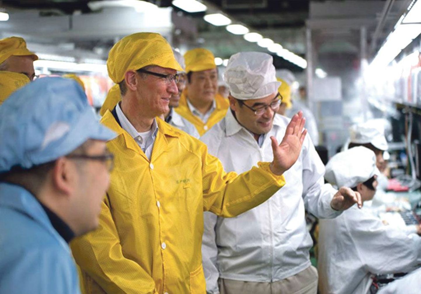 Гендиректор Apple Тим Кук знакомится со сборкой iPhone на заводе компании Foxconn в технологическом парке в китайском городе Чжэнчжоу. Недавно Кук пообещал, что предприятие инвестирует 100 млн долларов в то, чтобы вернуть производство компьютеров в США.
