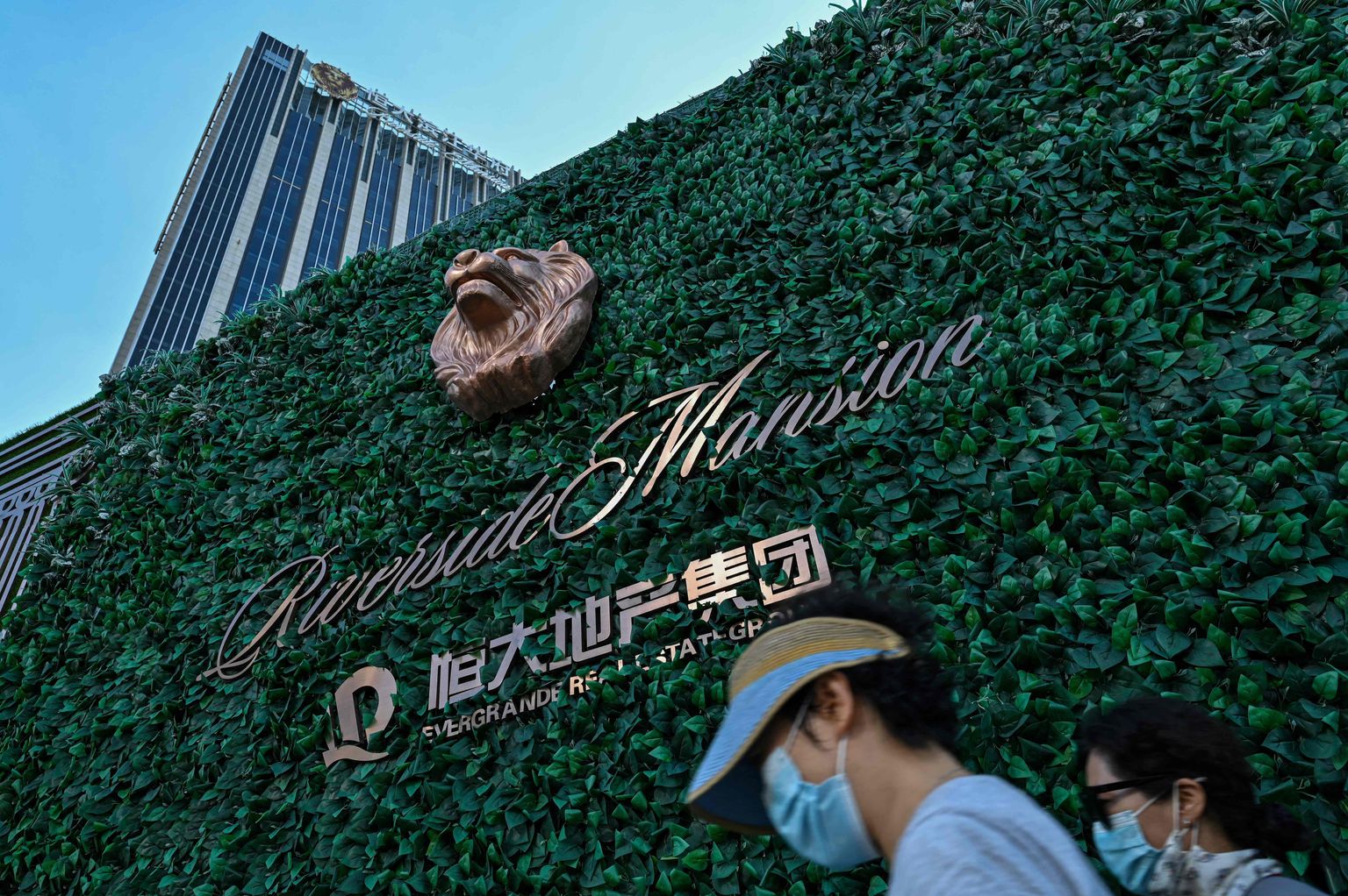 Mees ja naine möödumas vaaruva kinnisvarahiiu Evergrande'i glamuurarendusest Riverside Mansion Shanghais käesoleva aasta 22. septembril.