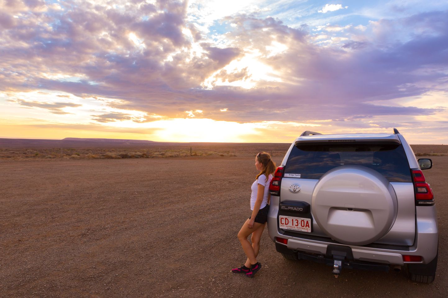 Naine autoga Austraalia kõrbes. Pilt on illustreeriv