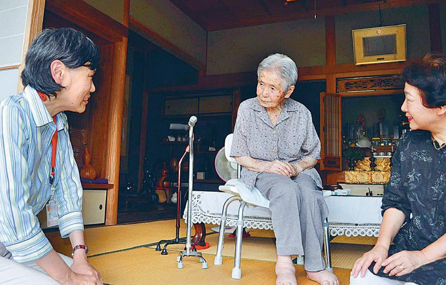 Kobe linna ametnik (vasakul) eelmisel nädalal 100-aastast Mitsue Wataset (keskel) tema kodus külastamas. Ametnikud alustasid ukselt uksele saja-aastaste läbikäimist, et järele uurida, kas kõik ikka elus on.