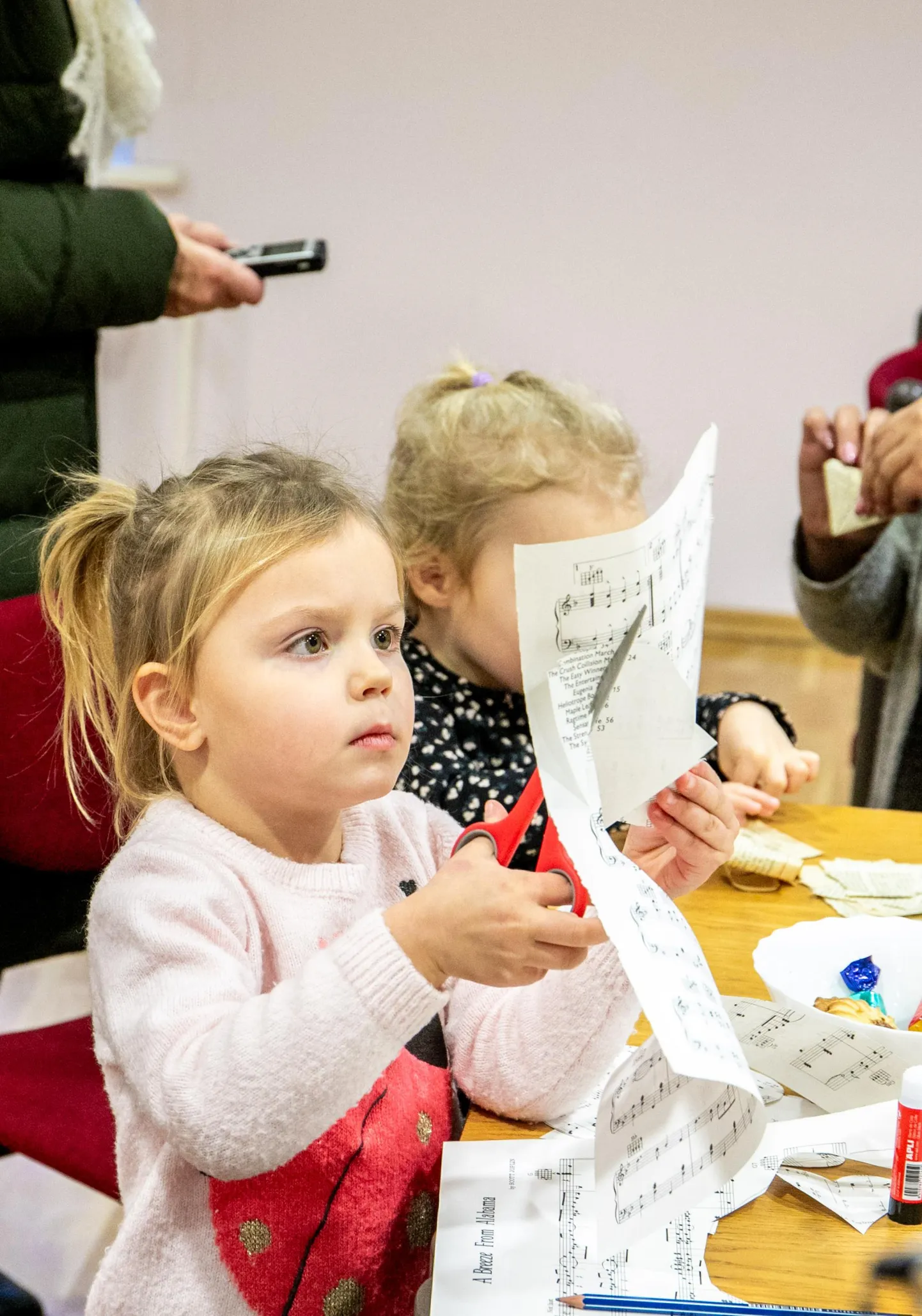 Naiste kõrval lõikasid-voltisid-liimisid paberit lapsed.