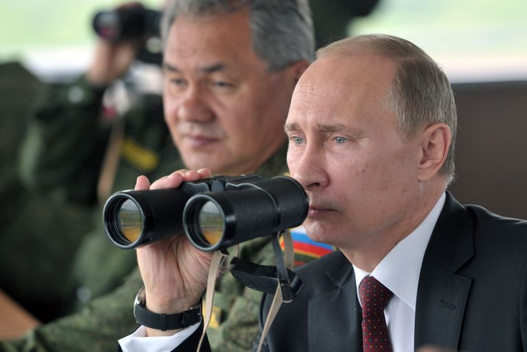 Владимир Путин и министр обороны РФ Сергей Шойгу наблюдают за военными учениями на Сахалине в июле 2013 года