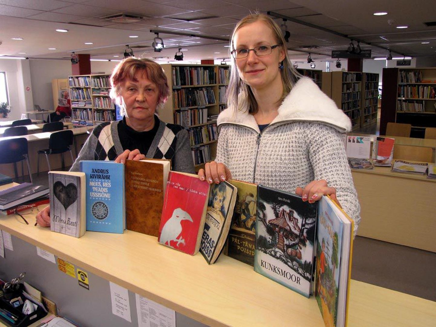 Viljandi linnaraamatukogu teenindusjuht Maire Killar ja direktor Reet Lubi näitavad eelmise aasta populaarsemaid raamatuid.