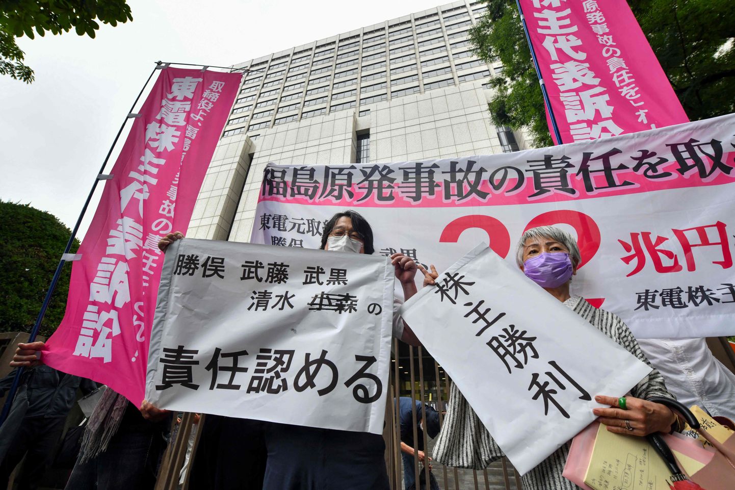 Plaintiffs in the Tokyo Electric Power Company (TEPCO) shareholder derivative suit, brought by shareholders over the nuclear disaster triggered by the 2011 tsunami, react following the court's decision outside the Tokyo District Court on July 13, 2022. - A Tokyo court on July 13 ordered former executives from the operator of the Fukushima nuclear plant involved in the 2011 disaster to pay around 94.8 billion USD in damages, local media said. (Photo by Kazuhiro NOGI / AFP)