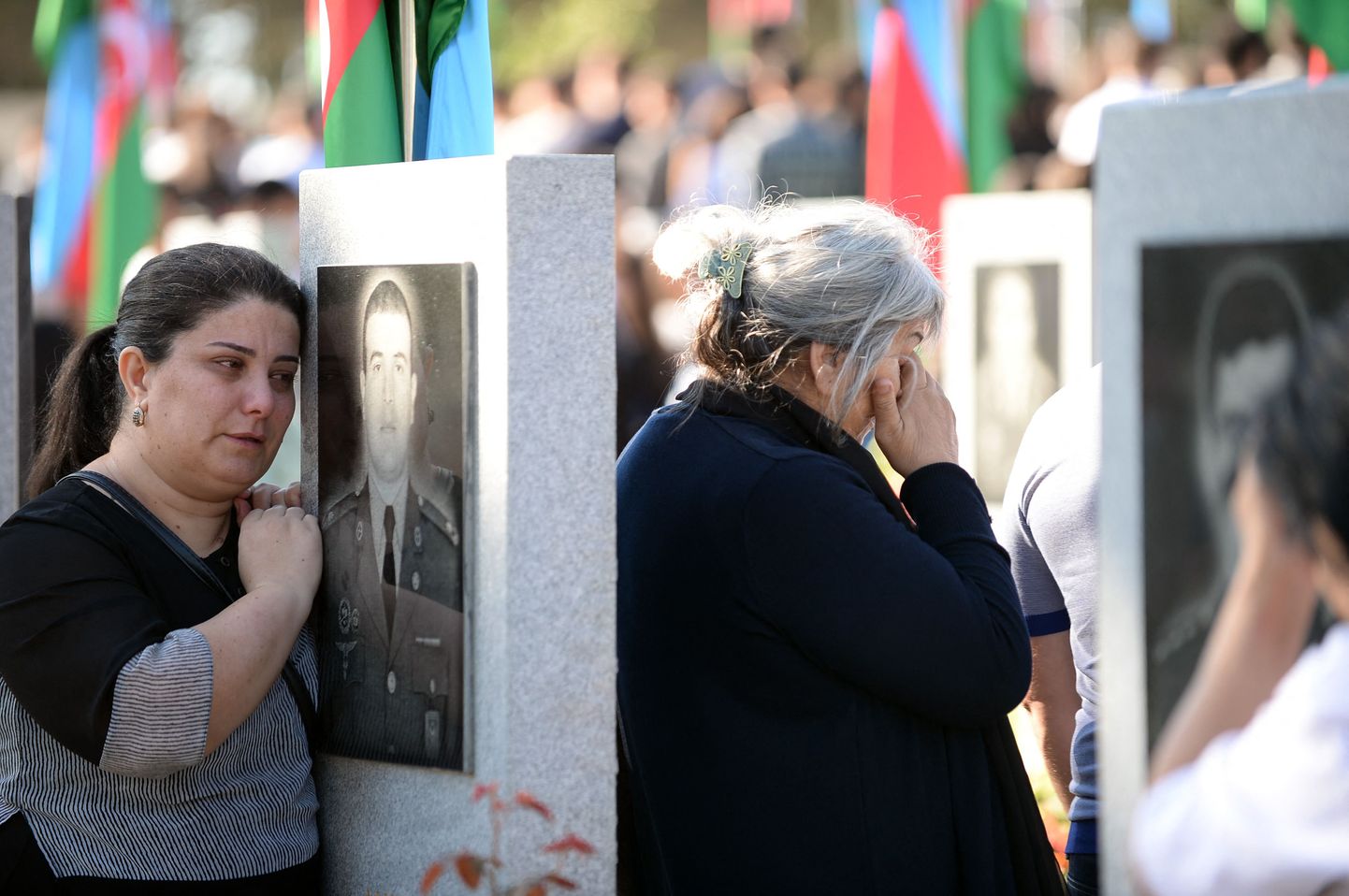 Родственники на могилах погибших в ходе военного конфликта в Нагорном Карабахе, 27 сентября.