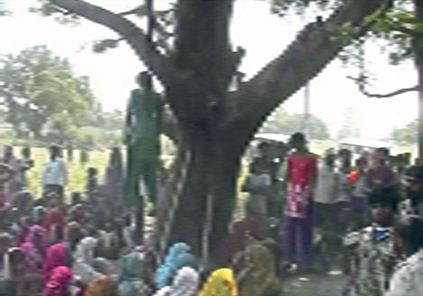 Жители деревни Катра собрались на месте убийства двух девушек. Трое мужчин, двое из них полицейские, изнасиловали сестер и затем повесили их на дереве.