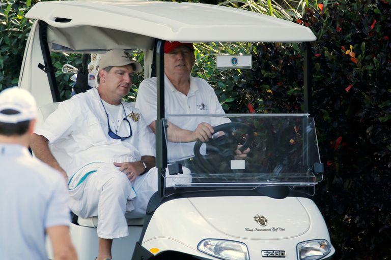 Donald Trump golfiautoga sõitmas.