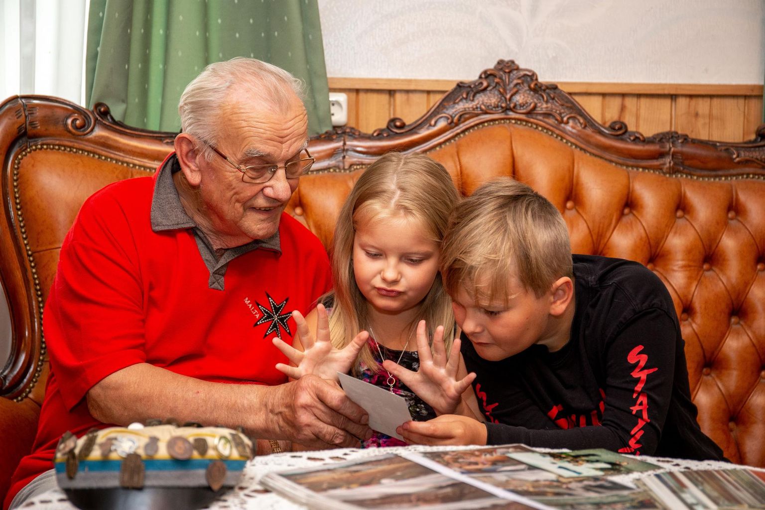 Eedu-­Enno talu elutoas näitab vanaisa Eduard lastelastele vanu fotosid, meenutades eelmisi pidusid. Nii mõnigi aastaarv ja lugu üllatab mudilasi.