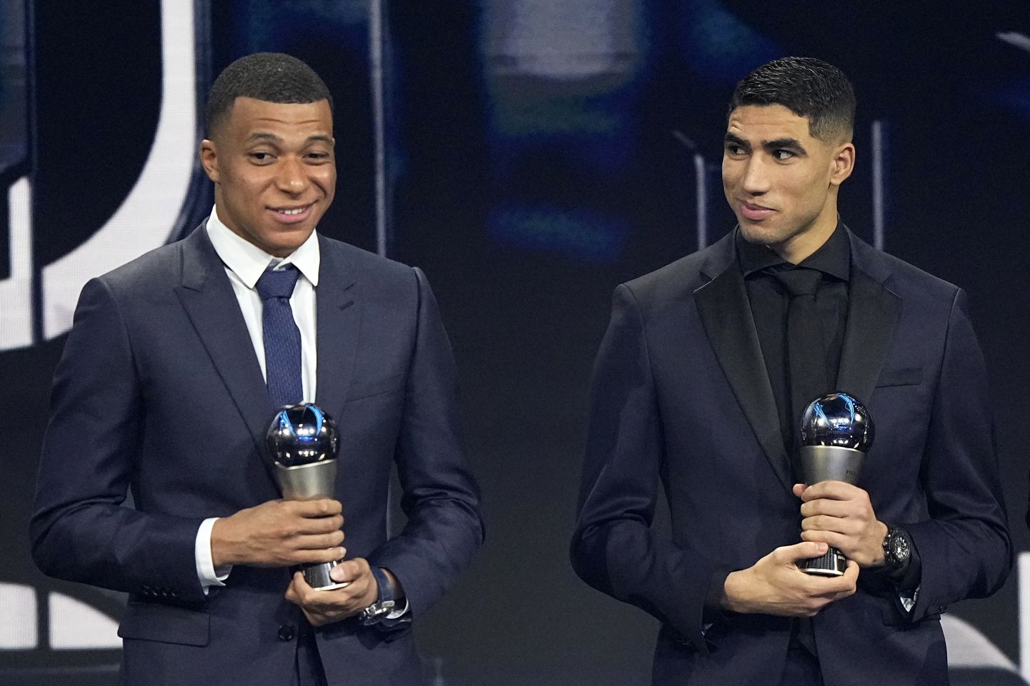 Kylian Mbappe, left, and Achraf Hakimi, pose with trophies Men's World 11 during the ceremony of the Best FIFA Football Awards in Paris, France, Monday, Feb. 27, 2023. (AP Photo/Michel Euler)  XDMV150
