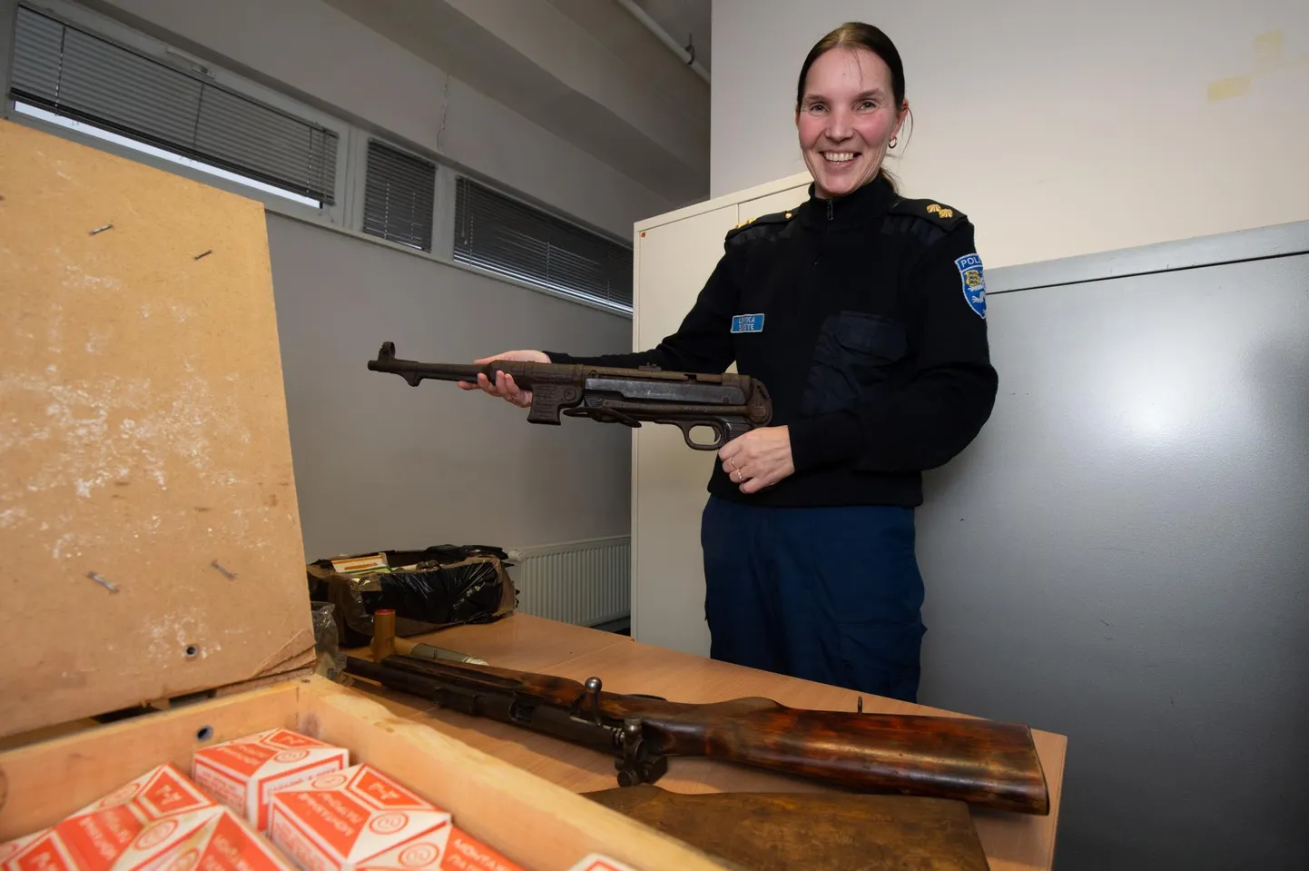 Lõuna prefektuuri lubadeametnik Liivika Suiste näitas ebaseaduslike relvade loovutamise kampaania käigus politseile üle antud väga heas korras püstolkuulipildujat. Tema ees puidust kastis on loovutatud montaažipadrunid.