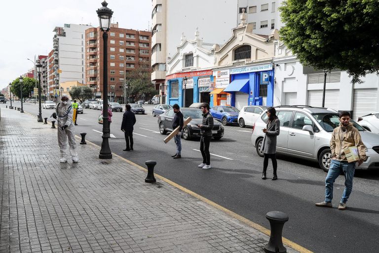 Valencia inimesed hoiavad postkontori järjekorras kaaslinlasest eemale, samal ajal toimub linnas ulatuslik tänavate desinfitseerimine. 