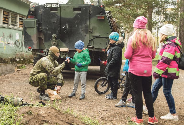 Asulates toimetavaid sõdureid saadavad kohalikud lapsed.