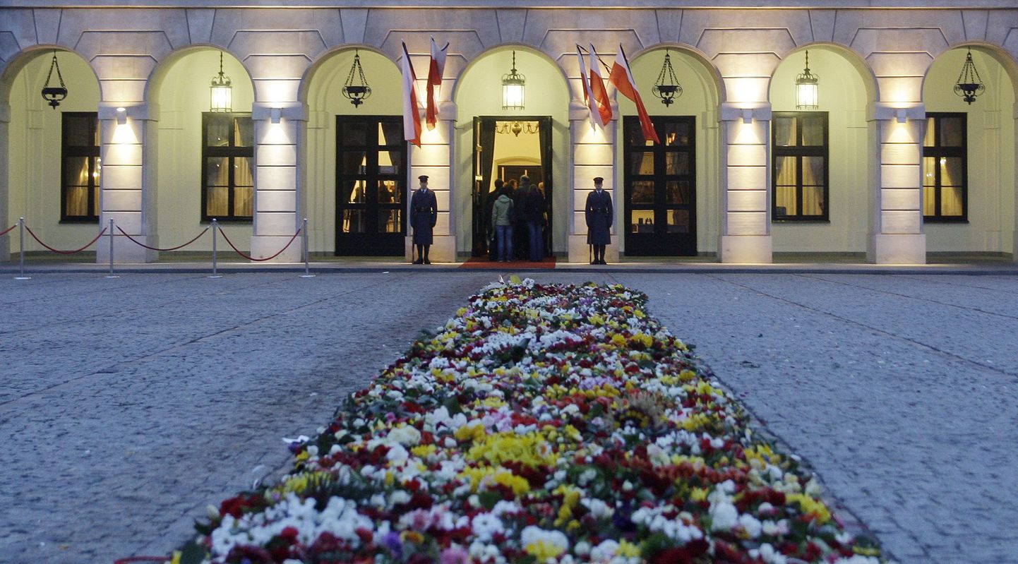 Valvemeeskond Poola presidendipalee sissepääsu juures Varssavis. Hukkunud esipaari mälestuseks on lippudel leinalindid.
