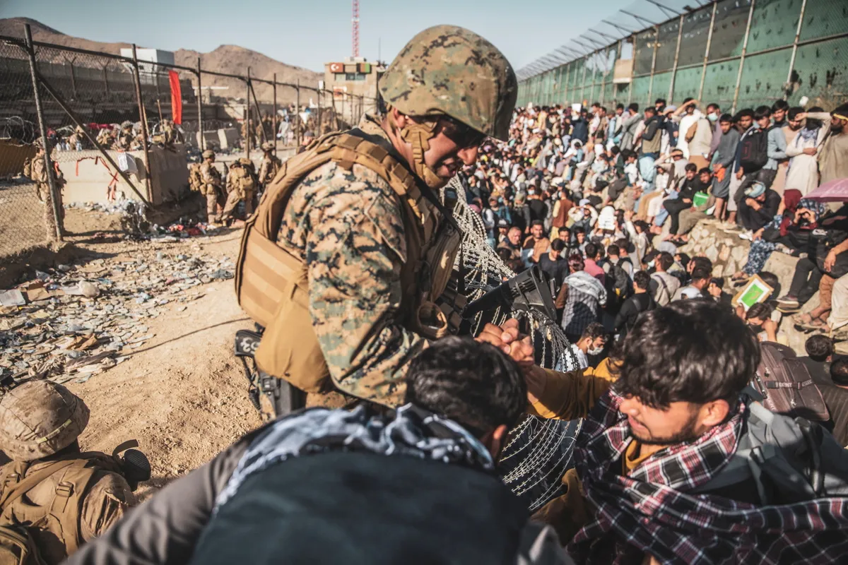 A U.S. Marine assists at an Evacuation Control Check Point (ECC) during an evacuation at Hamid Karzai International Airport, Kabul, Afghanistan, August 26, 2021.
