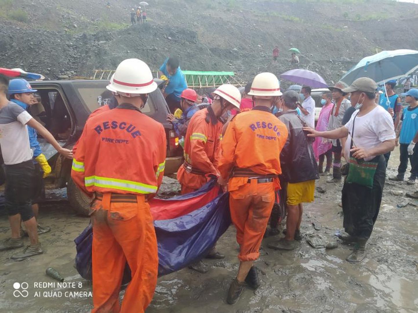 Myanmari päästjad õnnetuspaigas surnukeha kandmas.