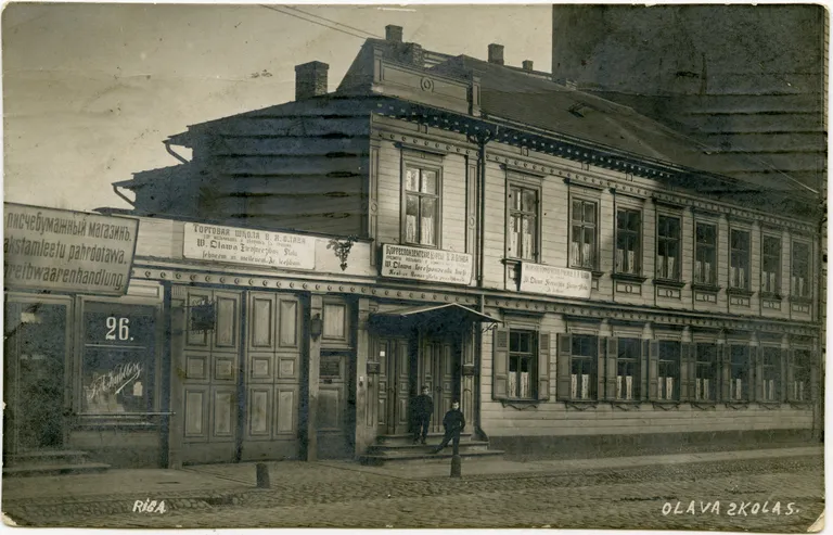Viļa Olava komercskola dibināta 1906. gadā. Līdz 1911. gadam tā atradās 1905. gadā celtajā ēkā Aleksandra Čaka ielā 26. No 1911. gada skola darbojās ēkā Marijas/Aleksandra Čaka ielā 30, pagalma korpusā. 1915. gadā skola tika evakuēta uz Pēterburgu, Rīgā darbu atsāka pēc diviem gadiem.