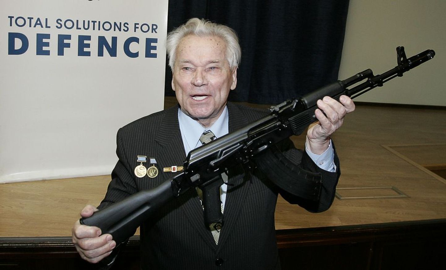 Vene kuulsa automaatrelva AK-47 looja Mihhail Kalašnikov koos tänapäevase mudeliga sellest relvast.