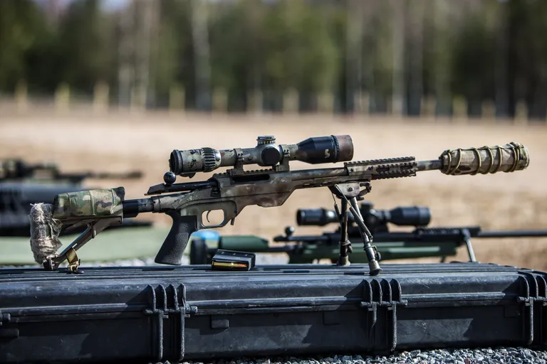 7,62x51 mm kaliibriga Tikka T3 Tactical, mida on tuunitud MDT raami, Ase Utra summuti ja Schmidt & Benderi 3-20x50 optikaga. Muide, viimane on varustatud ka peegeldusvastase võrguga, et snaipri asukohta mitte reeta. Kaba on sätitav laskja põse ja õla järgi.