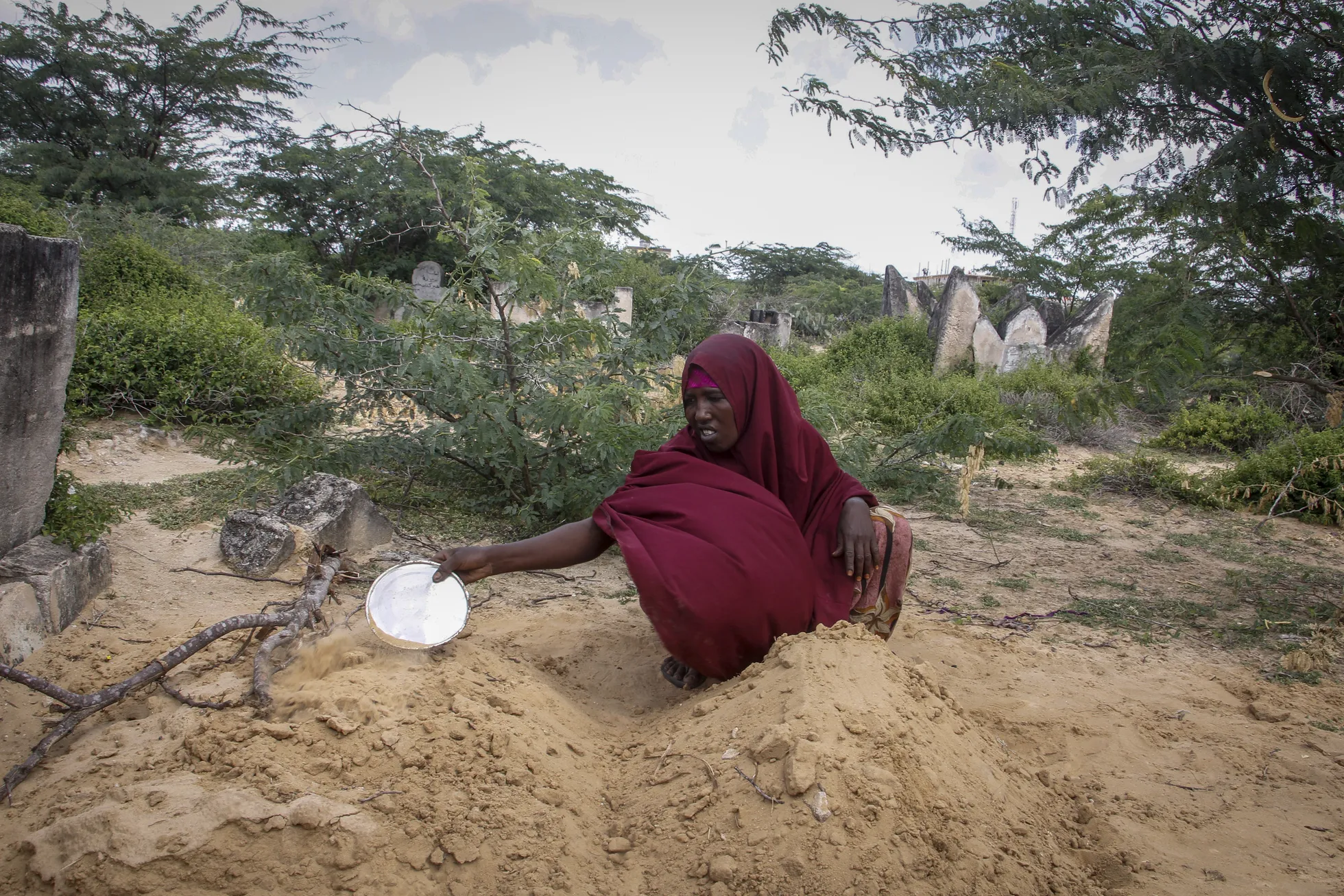 Fatuma Abdi Aliyow kohendab mulda alatoitumusest tingitud haigustesse surnud kahe poja haual Muqdisho äärelinna põgenikelaagris.